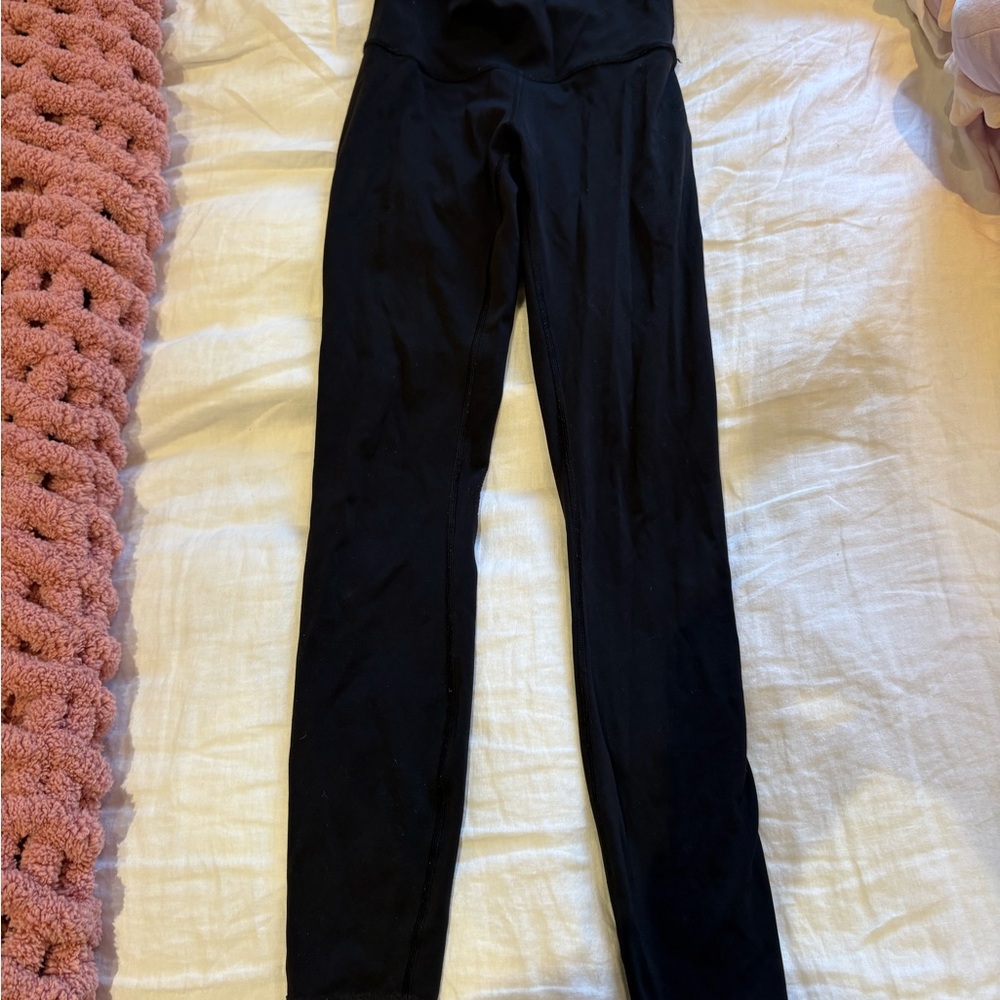 Black Lululemon leggings, athletic material. Full length.